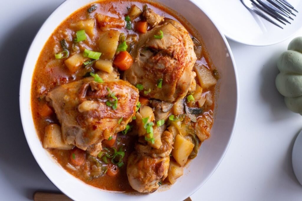 Tender chicken stew with carrots, potatoes, and herbs in savory sauce.